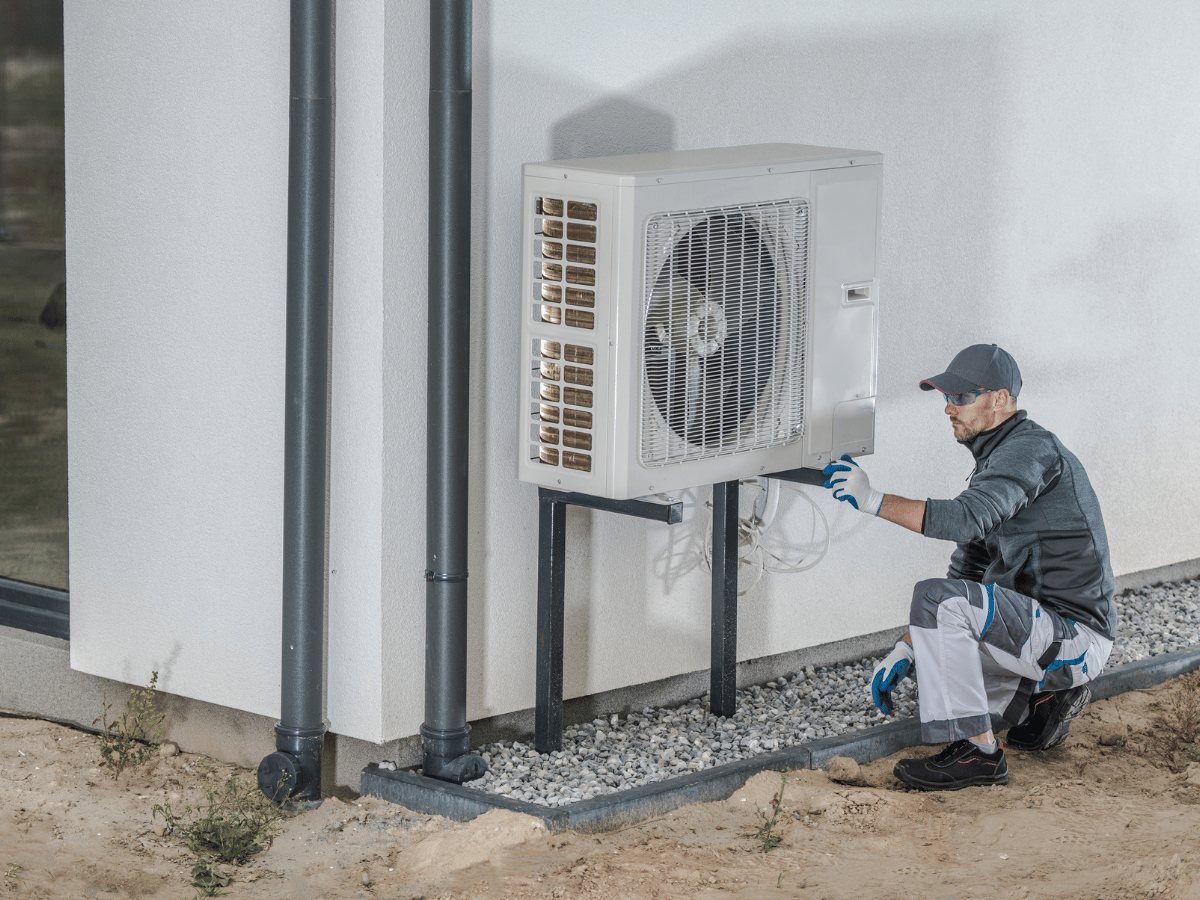 HVAC technician repairing an outdoor heat pump unit at a residential property in Powhatan, VA